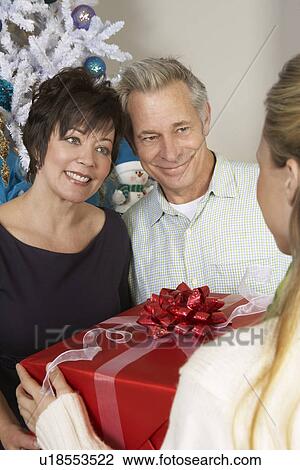 Woman handing senior couple present View Large Photo Image Stock Image - Woman handing senior couple present. Fotosearch