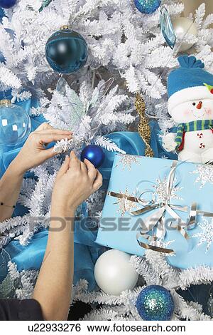 Woman hanging ornament on Christmas tree View Large Photo Image Stock Photograph - Woman hanging ornament on Christmas tree. Fotosearch