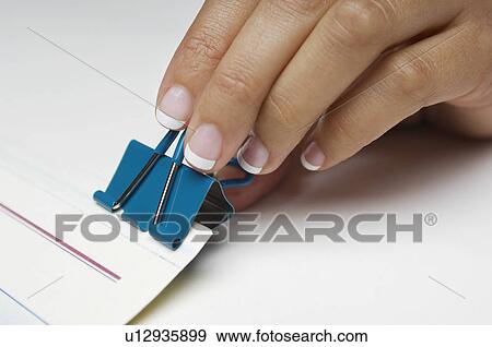 Woman holding binder clip, close-up of hand View Large Photo Image Stock Photo - Woman holding binder clip, close-up of hand. Fotosearch