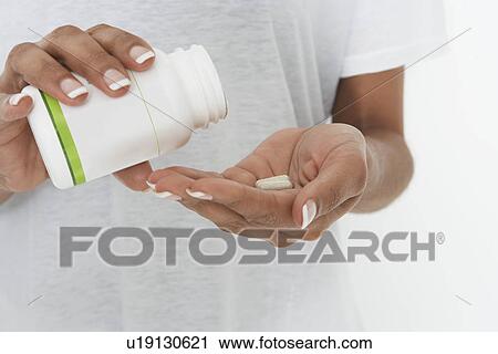 Woman holding bottle of pills, mid section View Large Photo Image Stock Image - Woman holding bottle of pills, mid section. Fotosearch