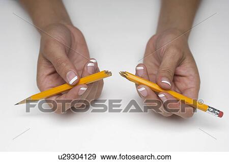 Stock Photo - Woman holding broken pencil, close-up of hands. Fotosearch