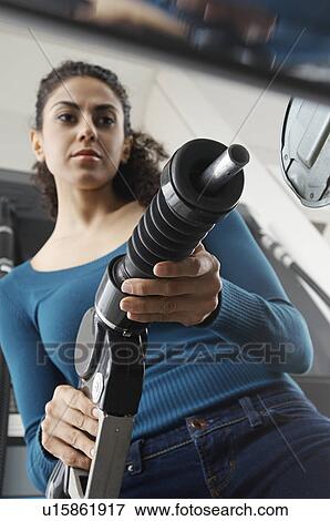 Woman holding fuel pump at gas station, tilt View Large Photo Image Stock Photo - Woman holding fuel pump at gas station, tilt. Fotosearch