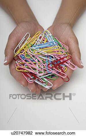 Stock Image - Woman holding handfull of paper clips. Fotosearch