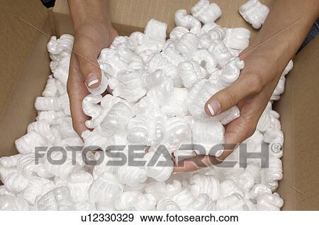 Stock Photo - Woman holding heap of packing peanut, close-up of hands. Fotosearch