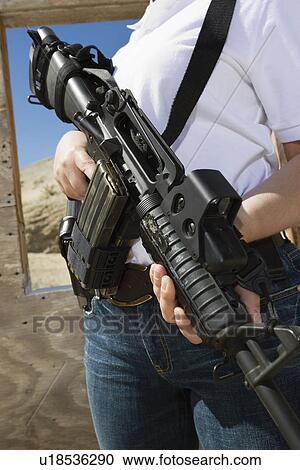 Woman holding machine gun at firing range, mid section View Large Photo Image Stock Image - Woman holding machine gun at firing range, mid section. Fotosearch