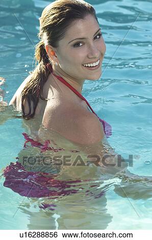 Woman in bikini in water smiling over shoulder, portrait View Large Photo Image Stock Photograph - Woman in bikini in water smiling over shoulder, portrait. Fotosearch