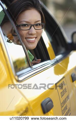 Stock Photo - Woman in glasses looking out taxi window. Fotosearch