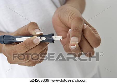 Stock Photo - Woman injecting insulin using syringe, close-up of hands. Fotosearch
