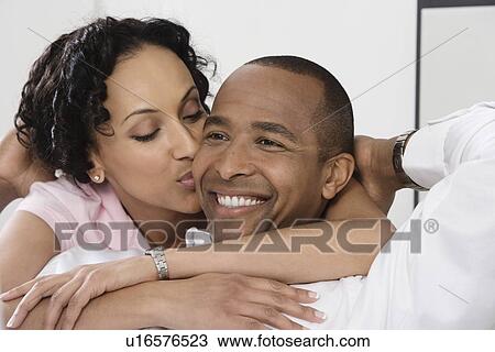 Stock Image - Woman Kissing Smiling Man. Fotosearch