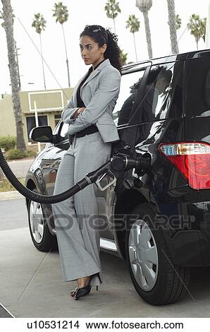 Woman leaning on van with fuel pump in it View Large Photo Image Picture - Woman leaning on van with fuel pump in it. Fotosearch
