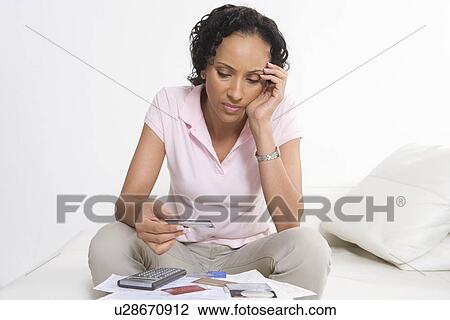 Stock Image - Woman Looking at Credit Cards. Fotosearch