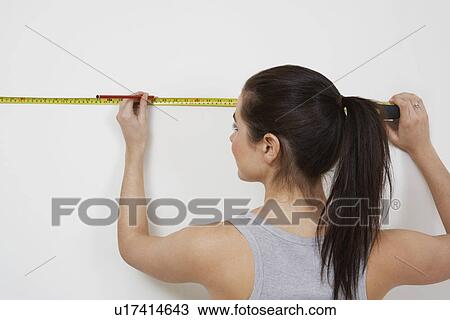 Woman measuring wall View Large Photo Image Stock Image - Woman measuring wall. Fotosearch