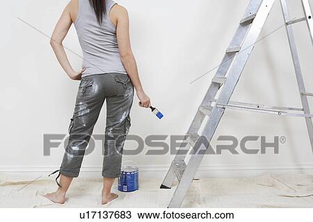 Stock Image - Woman painting wall. Fotosearch