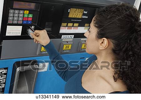 Woman paying with credit card at gas pump View Large Photo Image Stock Photo - Woman paying with credit card at gas pump. Fotosearch