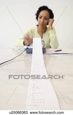 Stock Image - Woman Reading Adding Machine Tape. Fotosearch