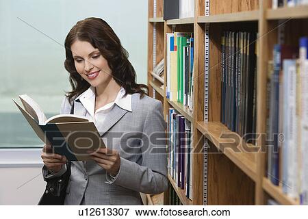 Stock Photo - Woman reading in library. Fotosearch