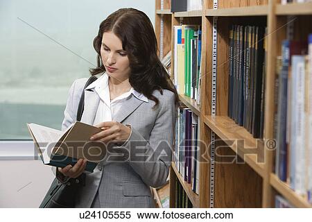 Stock Photography - Woman reading in library. Fotosearch