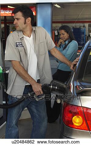Woman watching gas station attendant pumping gas View Large Photo Image Stock Image - Woman watching gas station attendant pumping gas. Fotosearch