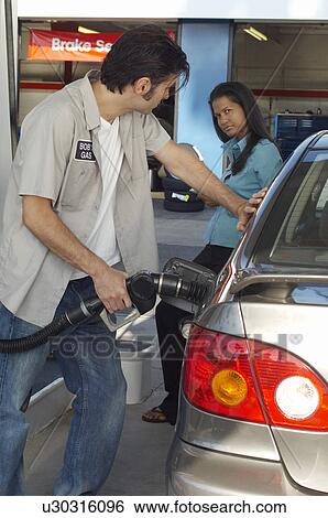 Woman watching gas station attendant pumping gas View Large Photo Image Stock Photograph - Woman watching gas station attendant pumping gas. Fotosearch