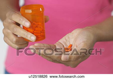 Woman's hands holding pills and bottle, close-up View Large Photo Image Stock Photograph - Woman's hands holding pills and bottle, close-up. Fotosearch
