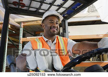 Stock Image - Worker Driving a Forklift. Fotosearch