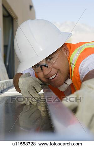Stock Photo - Workman Sighting Along a Beam. Fotosearch