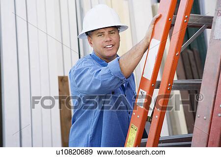 Stock Photo - Workman Standing by a Ladder. Fotosearch
