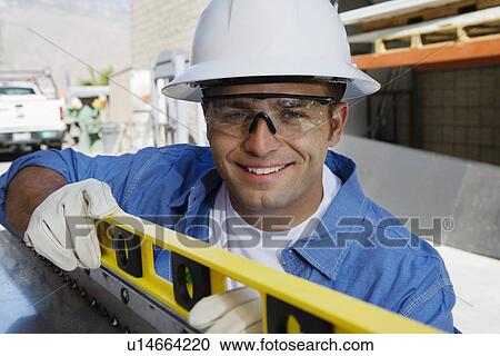 Stock Image - Workman Using a Spirit Level. Fotosearch