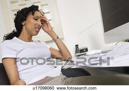 Stock Image - Worried Woman Doing Finances. Fotosearch