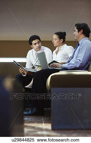 Stock Photography - Young business people working in office. Fotosearch