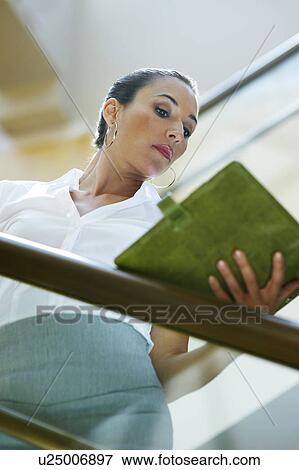 Stock Photo - Young business woman holding notepad. Fotosearch