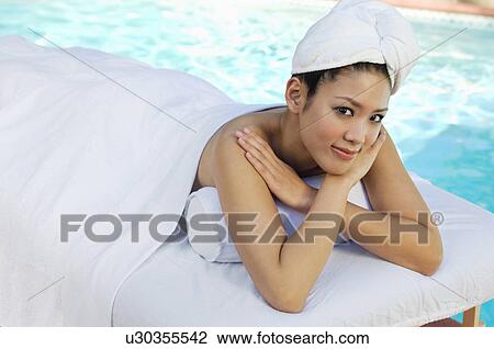 Young Chinese woman lying under towel by swimming pool, portrait View Large Photo Image Stock Image - Young Chinese woman lying under towel by swimming pool, portrait. Fotosearch