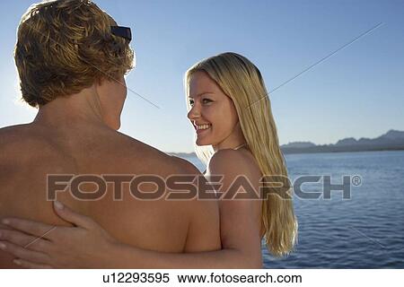 Stock Photography - Young couple embracing at lake. Fotosearch