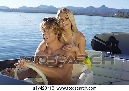 Stock Photo - Young couple embracing in boat on lake. Fotosearch