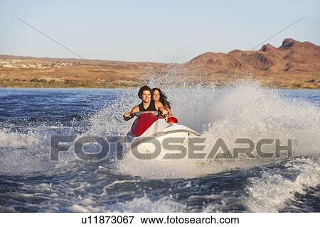 Young couple riding jetski on lake View Large Photo Image Stock Photo - Young couple riding jetski on lake. Fotosearch
