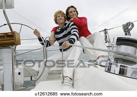 Stock Photography - Young couple smiling on sailboat. Fotosearch