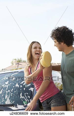 Young couple washing car outdoors View Large Photo Image Stock Photo - Young couple washing car outdoors. Fotosearch