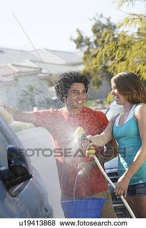 Young couple washing car View Large Photo Image Stock Photo - Young couple washing car. Fotosearch