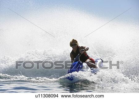 Young man riding jetski on lake View Large Photo Image Picture - Young man riding jetski on lake. Fotosearch