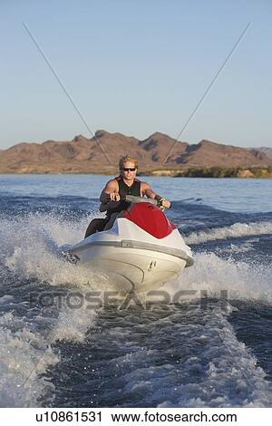 Young man riding jetski on lake View Large Photo Image Stock Image - Young man riding jetski on lake. Fotosearch