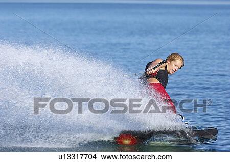 Picture - Young man wakeboarding on lake. Fotosearch