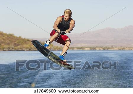 Young man wakeboarding on lake View Large Photo Image Stock Image - Young man wakeboarding on lake. Fotosearch