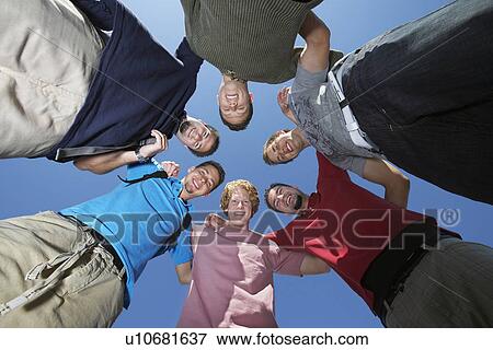 Stock Photo - Young men in circle, view from below. Fotosearch