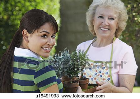 Stock Image - Young woman and mother gardening, portrait. Fotosearch