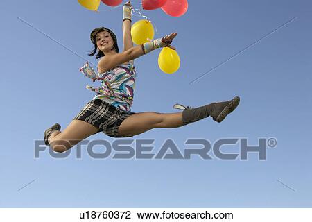Young woman doing splits in air holding balloons View Large Photo Image Stock Image - Young woman doing splits in air holding balloons. Fotosearch