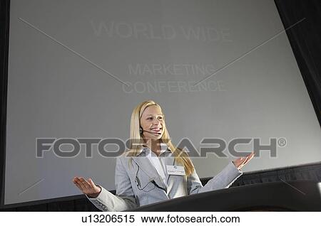Stock Photography - Young woman during presentation at conference. Fotosearch