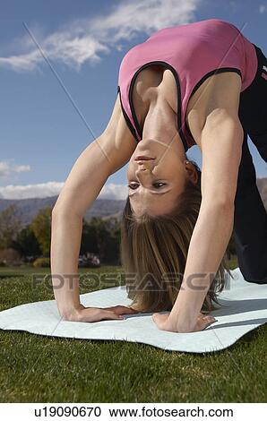 Young woman exercising in park View Large Photo Image Stock Image - Young woman exercising in park. Fotosearch
