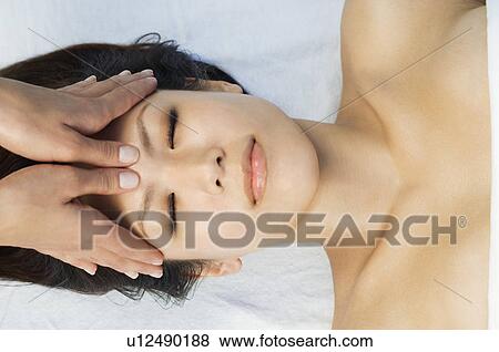 Stock Photo - Young woman having head massage at health spa. Fotosearch