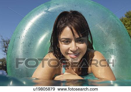 Young woman in inflatable ring in swimming pool, close-up View Large Photo Image Stock Photo - Young woman in inflatable ring in swimming pool, close-up. Fotosearch