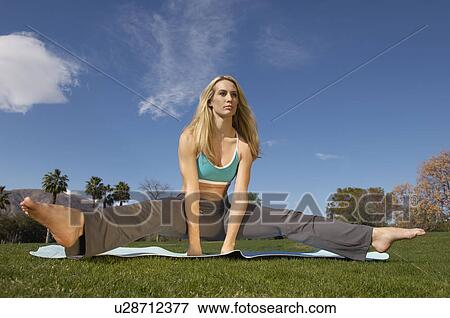 Young woman performing yoga exercises in park View Large Photo Image Stock Photo - Young woman performing yoga exercises in park. Fotosearch